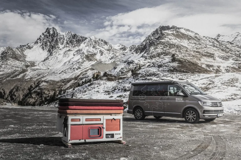 Campingbox EGOÉ Nestbox Roamer auf Parkplatz freistehend im Hintergrund VW T5 / T6 in Berglandschaft